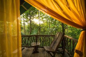 福尔图纳La Tigra Rainforest Lodge的门廊上的木椅和帐篷
