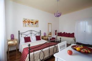 鲁比科内河畔萨维纳诺Il Portico Camere e Caffè - centro Città的一间卧室配有一张床和一张桌子及一碗水果