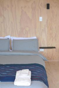 阿希帕拉The Huts的一间卧室配有带毛巾的床