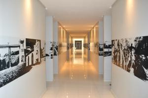 皮拉尼亚斯Dunen Hotel的墙上挂着黑白照片的建筑物走廊
