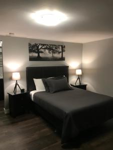 One Hundred Mile House94 Motel & RV Park的一间卧室配有一张大床和两盏灯
