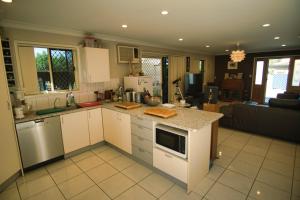 布里斯班Mount Gravatt Guesthouse的厨房配有白色橱柜和台面