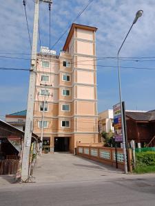 华欣班帕克山姆阿农公寓式酒店的前面有栅栏的一座高大的棕褐色建筑