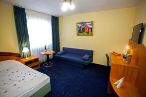 捷克布杰约维采萨沃伊酒店的酒店客房,配有床和蓝色的沙发