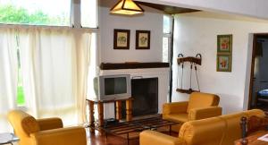Campo Quijano查瓦希卡瓦尼亚斯酒店的客厅配有黄色椅子和电视