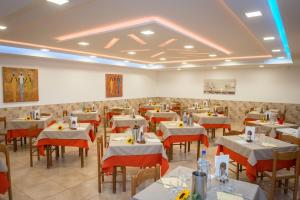 维耶斯泰Albergo Torrente的用餐室配有白色的桌子和红色的椅子