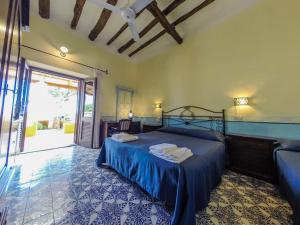 圣马里纳萨利纳Hotel Arcangelo - Salina的一间卧室配有一张带蓝色床罩的床