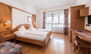 瓦尔道拉阿尔普克龙莫亚里霍夫酒店的配有一张床和一张书桌的酒店客房