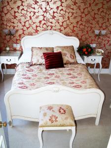海斯廷斯1066塔楼旅馆的一张带红色枕头和两张桌子的白色床