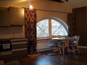 维尔纽斯City Dawn Gate Apartment的厨房配有桌椅和窗户。