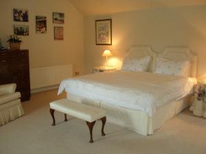 卡洛Courtyard Cottage的卧室配有一张白色大床和一把椅子