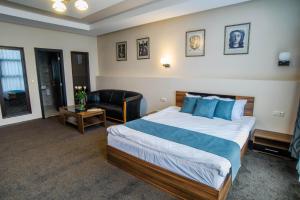 扬博尔Park-Hotel Yambol的酒店客房带一张大床和一把椅子