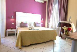 圣雷莫贝尔索吉欧诺酒店的一间卧室配有一张床和紫色的墙壁