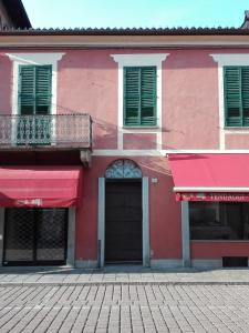 卡尔马尼奥拉Casa Ternavassi的一条街上有红色遮阳篷的粉红色建筑
