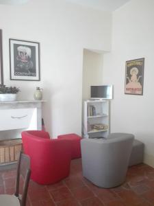 卡尔马尼奥拉Casa Ternavassi的客厅配有红色椅子和壁炉