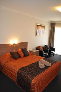 奥古斯塔港奥古斯塔庭院汽车旅馆的配有一张床和一把椅子的酒店客房