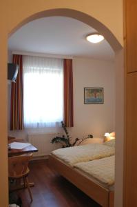 杜伦斯坦Weingut-Pension Stockingerhof的一间卧室配有一张床、一张书桌和一个窗户。