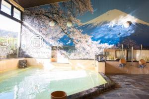 汤河原町和京日式酒店的墙上挂有山壁画的游泳池
