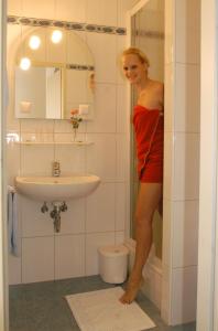 杜伦斯坦Weingut-Pension Stockingerhof的站在浴室里穿着红色衣服的女人
