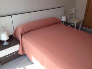 洛帕莞普迪卡旅馆的一间卧室配有一张大床和红色的床罩