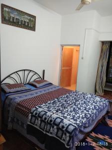 帕罗林Sobitai的一间卧室配有一张带蓝白色毯子的床