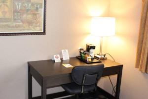 沃特敦水城戴斯酒店的一张桌子,位于酒店的房间,配有一盏灯和一把椅子