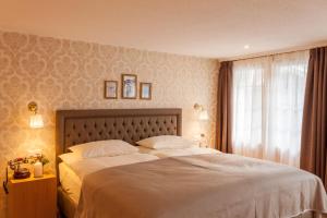 采尔马特Hotel Walliserhof Zermatt的一间卧室设有一张大床和一个窗户。