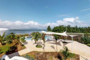 玛雅湾Dolphin @ Swan Villas的一个带游泳池和白色天篷的度假胜地