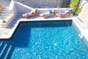 米利尼Villa Blue Diamond的一个带两把椅子的游泳池和一个游泳池