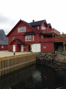 斯沃尔韦尔Svolværgeita Apartments的水体旁的红色房子