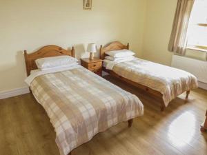 ClonburMaison de Kilbride Finney Clonbur Mayo的一间卧室设有两张床和窗户。