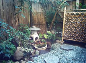 京都紫野度假屋的花园设有鸟浴缸和围栏