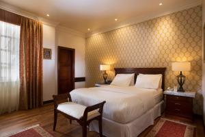 昆卡圣卢西亚精品酒店的一间卧室配有一张大床和一把椅子