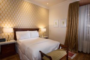 昆卡圣卢西亚精品酒店的配有一张床和一把椅子的酒店客房