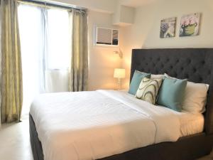 宿务One Bedroom Apartment at Sundance Residences with Hi-Speed WiFi的一间卧室设有一张大床和一个窗户。