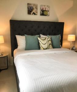 宿务One Bedroom Apartment at Sundance Residences with Hi-Speed WiFi的一间卧室配有一张带两盏灯的大型白色床。