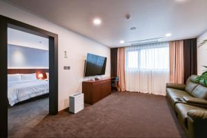 仁川市海月旅游酒店 的酒店客房,配有床和沙发