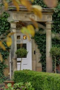 RisleyRisley Hall Hotel的常春藤房子的白色前门