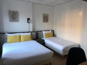鲁昂雷伊尼蒂耶酒店的客房 - 带两张带黄色枕头的床