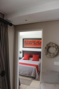 莫塞尔湾Seafront Apartment in Mossel Bay的一间卧室配有红色枕头的床