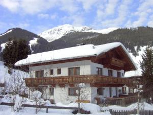 莱尔莫斯Haus Bergwelt的雪中带雪盖屋顶的房子