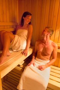 莫济列Etno House Gosteče- Suite with Finnish sauna的坐在桑拿里的男女