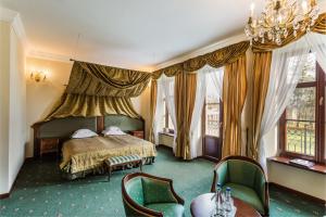 Kombornia迪沃尔柯姆波尔尼亚SPA酒店的一间卧室配有一张床、一些椅子和窗户