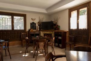 比努埃萨圣伊内斯乡村酒店 的一间带桌椅和电视的用餐室