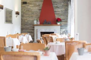洛迦诺Boutique-HOTEL REMORINO, a Private Selection Hotel的一间带桌椅和壁炉的用餐室
