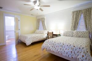 特拉弗勒斯雷斯特Swamp Rabbit Inn Travelers Rest的一间卧室配有两张床和吊扇