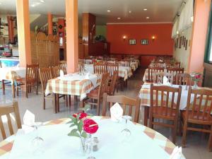 马希库家庭住宅酒店的餐厅设有白色的桌椅和鲜花