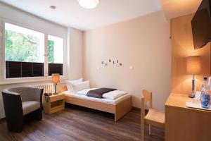 柏林镇公所酒店的卧室配有床、椅子和窗户。