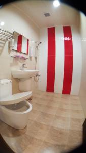 布袋龙园旅馆的一间带卫生间的浴室和红色及白色条纹墙
