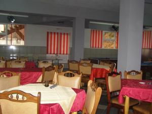 卡夫尼克El Stefano Srl的一间配备有桌椅和红色窗帘的用餐室
